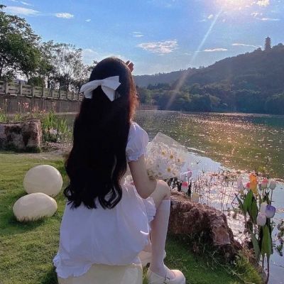 美丽的女人在白色的裙子摆姿势在紫色的马鞭草花田迷人的中国女孩与黑色的长发享受她的休闲时间户外_美女图片微信头像侧脸