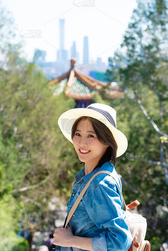 美丽的女孩长头发白色的裙子和帽子笑微笑调情在棕榈树和热带城市的背景下度假的女孩旅行晚上日_美女自拍背影微信头像